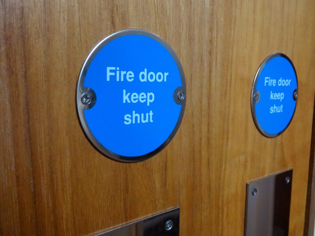 Circular blue Fire Door Keep Shut safety sign, fire doors